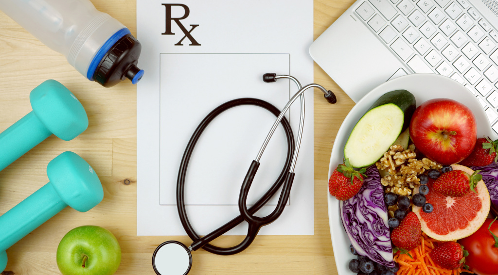 Image of hand weights, water bottle, fruit, stethoscope and laptop